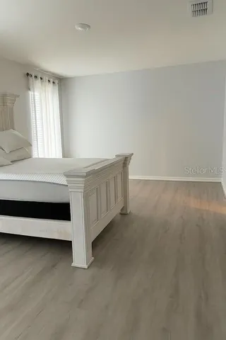 a spacious bedroom with a bed and a window