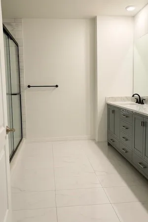 a bathroom with a granite countertop sink a mirror and a bathtub