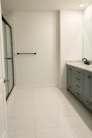 a bathroom with a granite countertop sink a mirror and a bathtub