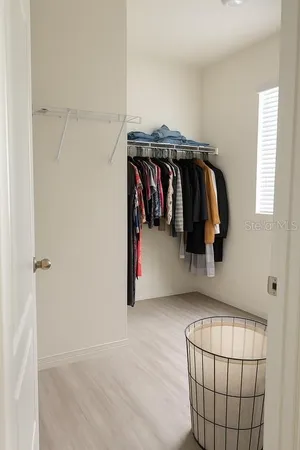a view of walk in closet with clothes and shoes