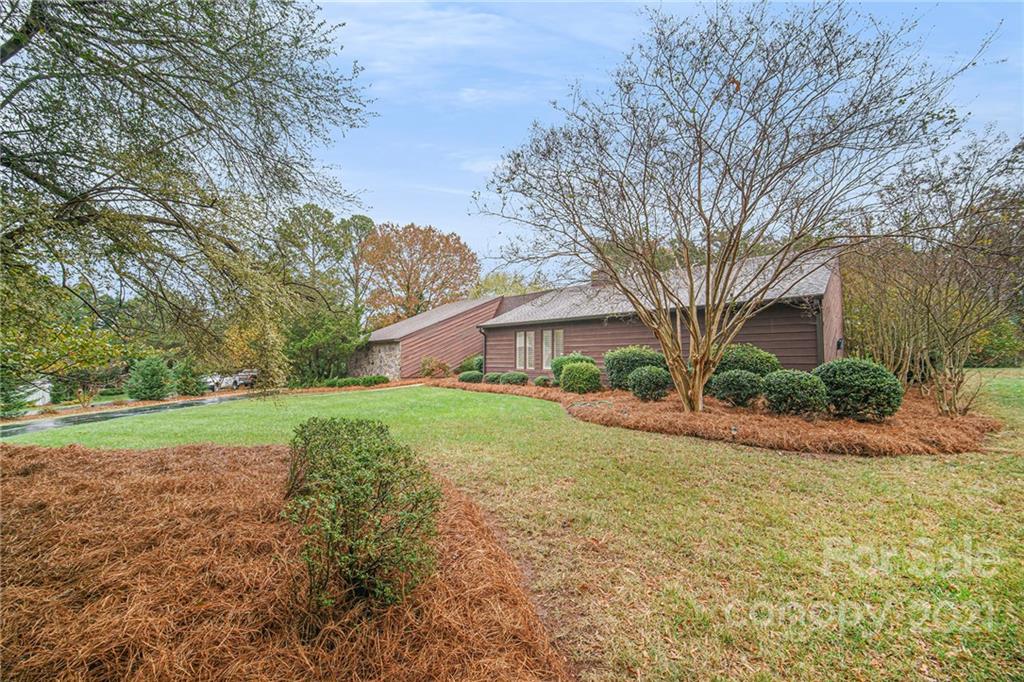 8001 Rising Meadow Road Charlotte, NC 28277 - Photo 2 of 40 a view of a house next to a big yard and large trees