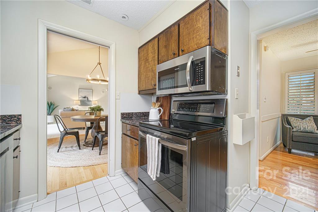 8001 Rising Meadow Road Charlotte, NC 28277 - Photo 17 of 40 a kitchen with stainless steel appliances granite countertop a stove top oven a sink a dining table and chairs