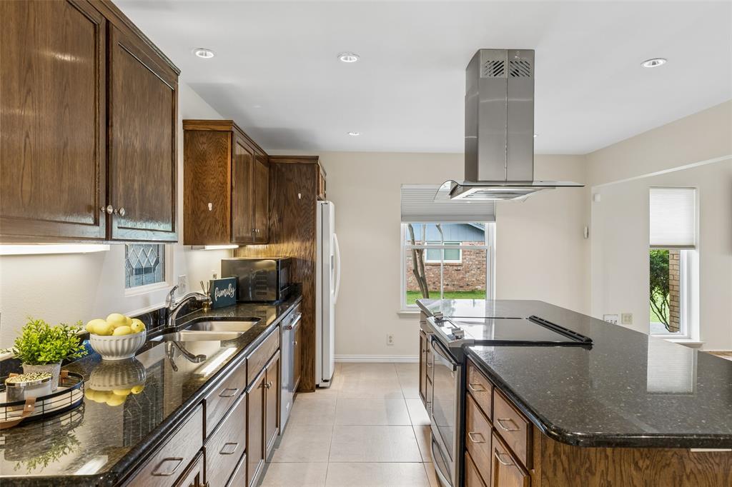 1548 Timbercreek Drive Howe, TX 75459 - Photo 8 of 24 a kitchen with stainless steel appliances granite countertop a sink a stove and a wooden floors