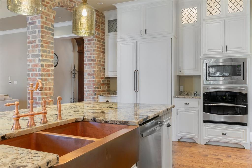 594 Turner Warnell Road Mansfield, TX 76063 - Photo 11 of 38 Kitchen featuring stainless steel appliances, white cabinets, light granite countertops, real hardwood floors, and decorative light fixtures