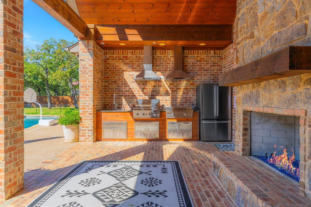 594 Turner Warnell Road Mansfield, TX 76063 - Photo 32 of 38 View of patio / terrace with area for grilling, an outdoor stone fireplace, and an outdoor pool