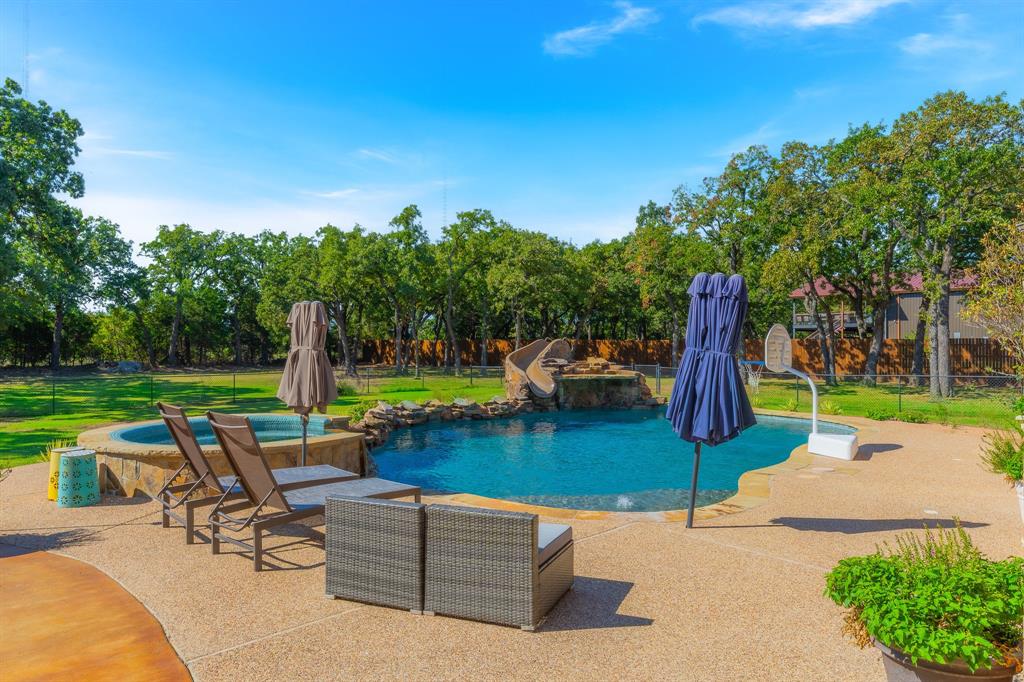 594 Turner Warnell Road Mansfield, TX 76063 - Photo 35 of 38 Outdoor pool with a patio, a fenced backyard, view of wooded area, and a water slide