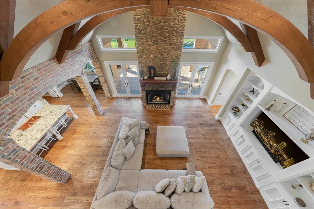 594 Turner Warnell Road Mansfield, TX 76063 - Photo 7 of 38 Living room with a fireplace, a high ceiling, read hardwood floors, beamed ceiling, and arched walkways