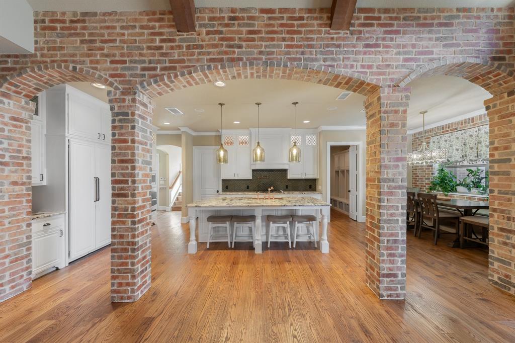 594 Turner Warnell Road Mansfield, TX 76063 - Photo 9 of 38 Kitchen with brick arched walkways, white cabinets, a breakfast bar area, and decorative light fixtures