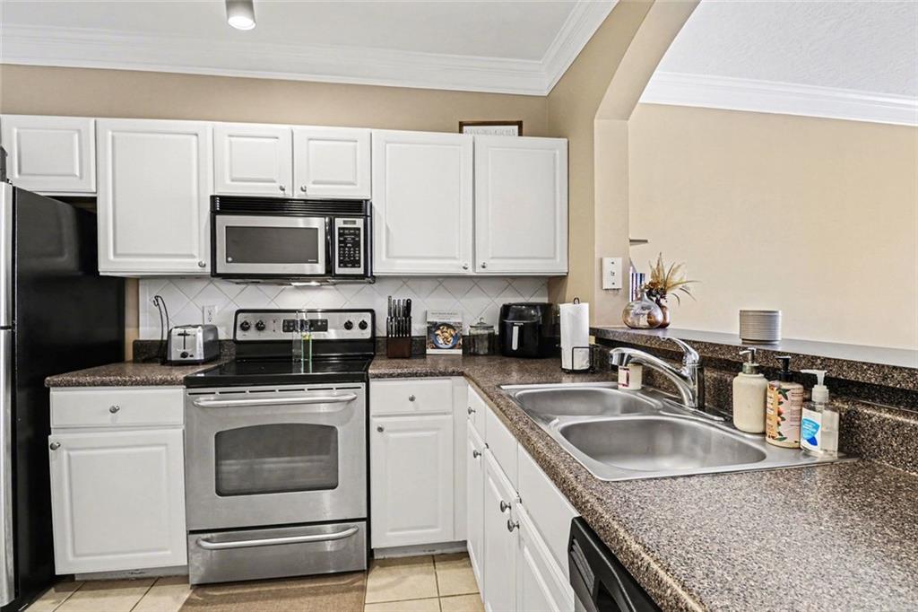 1319 Westchester Ridge Northeast Atlanta, GA 30329 - Photo 14 of 42 a kitchen with granite countertop a sink a stove top oven and cabinetry