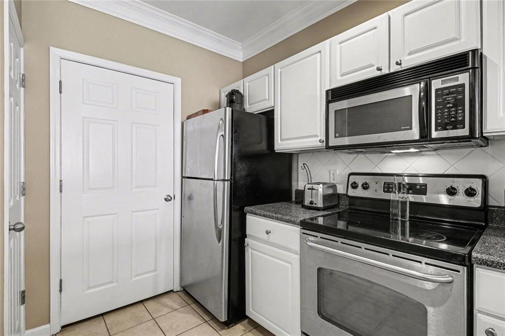 1319 Westchester Ridge Northeast Atlanta, GA 30329 - Photo 17 of 42 a kitchen with stainless steel appliances granite countertop white cabinets a refrigerator and a stove top oven