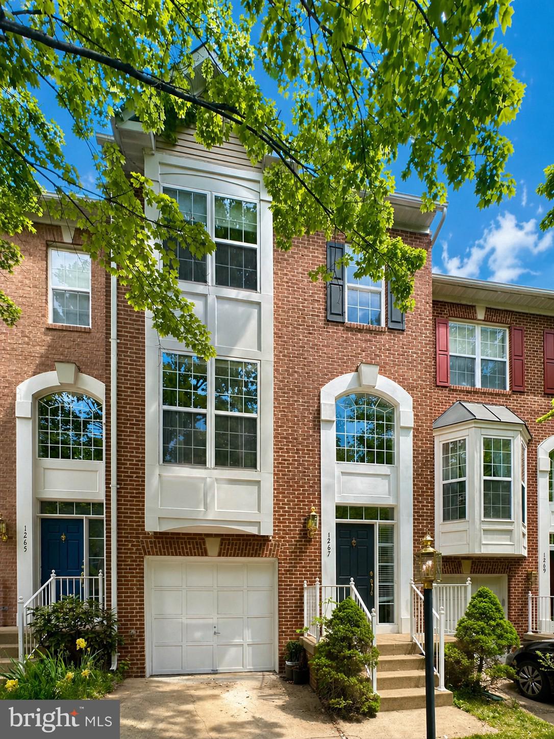 Charming brick townhouse with lush greenery.