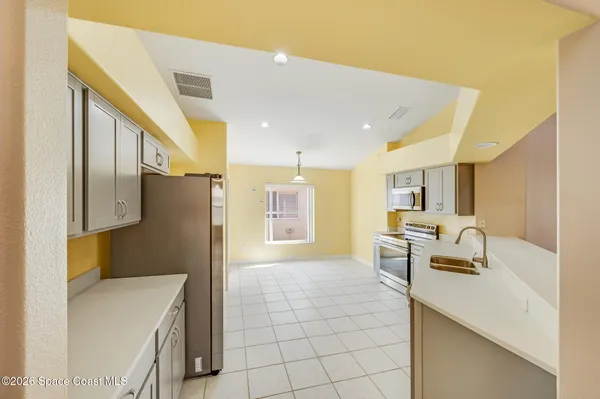 a kitchen with kitchen island a sink stainless steel appliances and cabinets