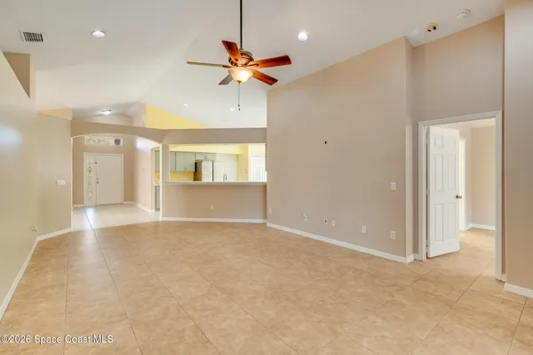 a view of a livingroom with a kitchen space with wooden floor