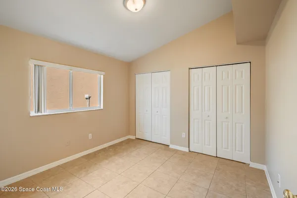 an empty room with cabinet and windows