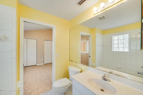 a bathroom with a sink and mirror with toilet