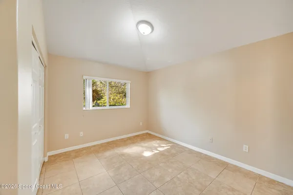 an empty room with a fan and a window