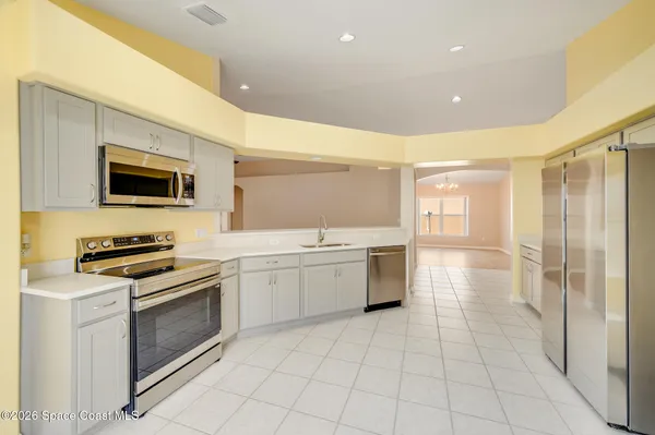 a kitchen with cabinets stainless steel appliances and a counter space