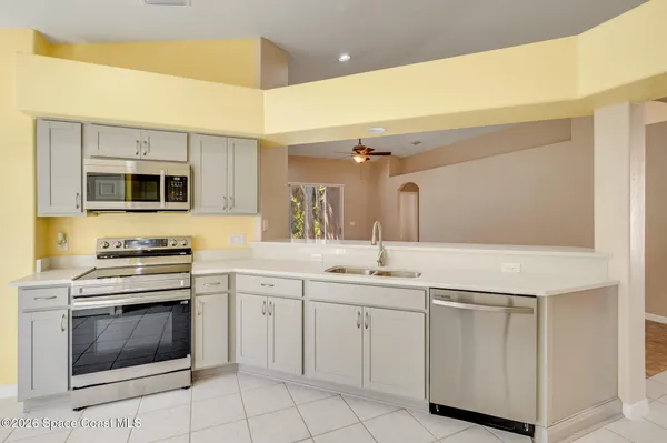 a view of an empty room with a kitchen