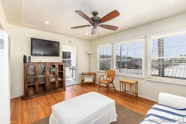 a living room with furniture and a flat screen tv with wooden floor