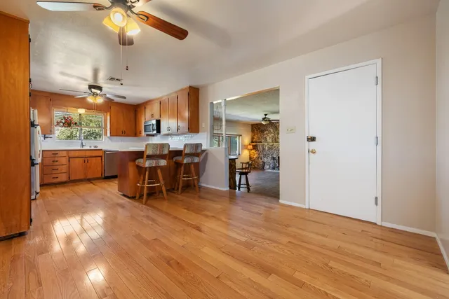 a kitchen with stainless steel appliances granite countertop a sink cabinets and wooden floor