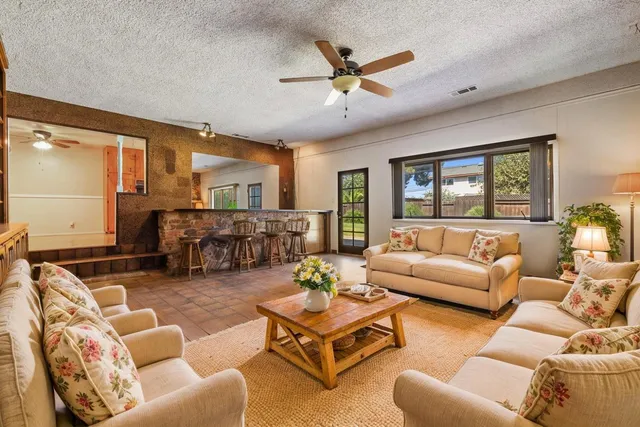 a living room with furniture ceiling fan and a wooden floor
