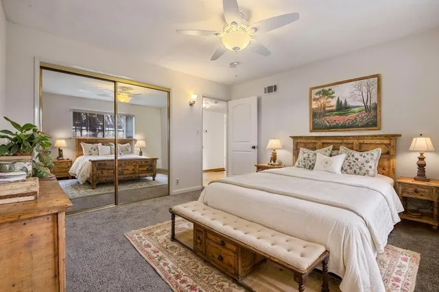 a bedroom with a bed a couch and potted plant