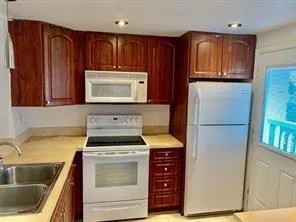 a kitchen with granite countertop a refrigerator stove and sink