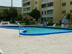 a view of swimming pool with a yard and plants