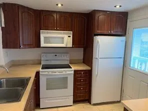 a kitchen with granite countertop a refrigerator stove and sink