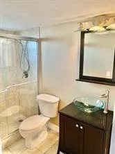a bathroom with a granite countertop sink toilet and shower