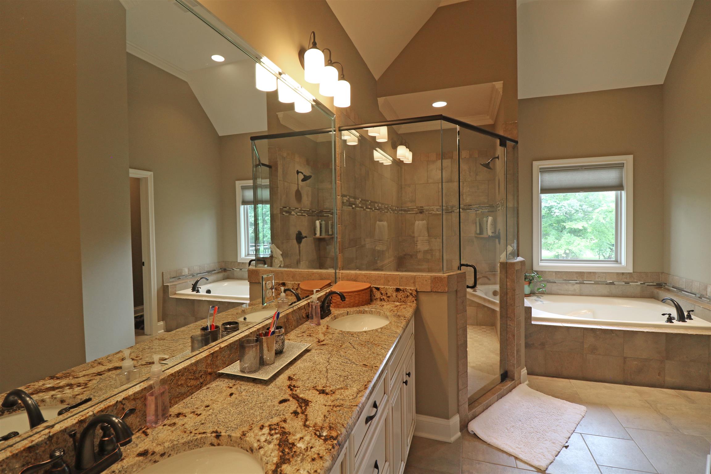 1235 Mires Road Mount Juliet, TN 37122 - Photo 17 of 30 Luxurious bathroom with tile flooring, crown molding, double bowl granite vanity, a separate linen closet, a large jetted tub with tile surrounds, an oversized walk-in tiled shower with a heavy glass door & bench seat, a separate water closet