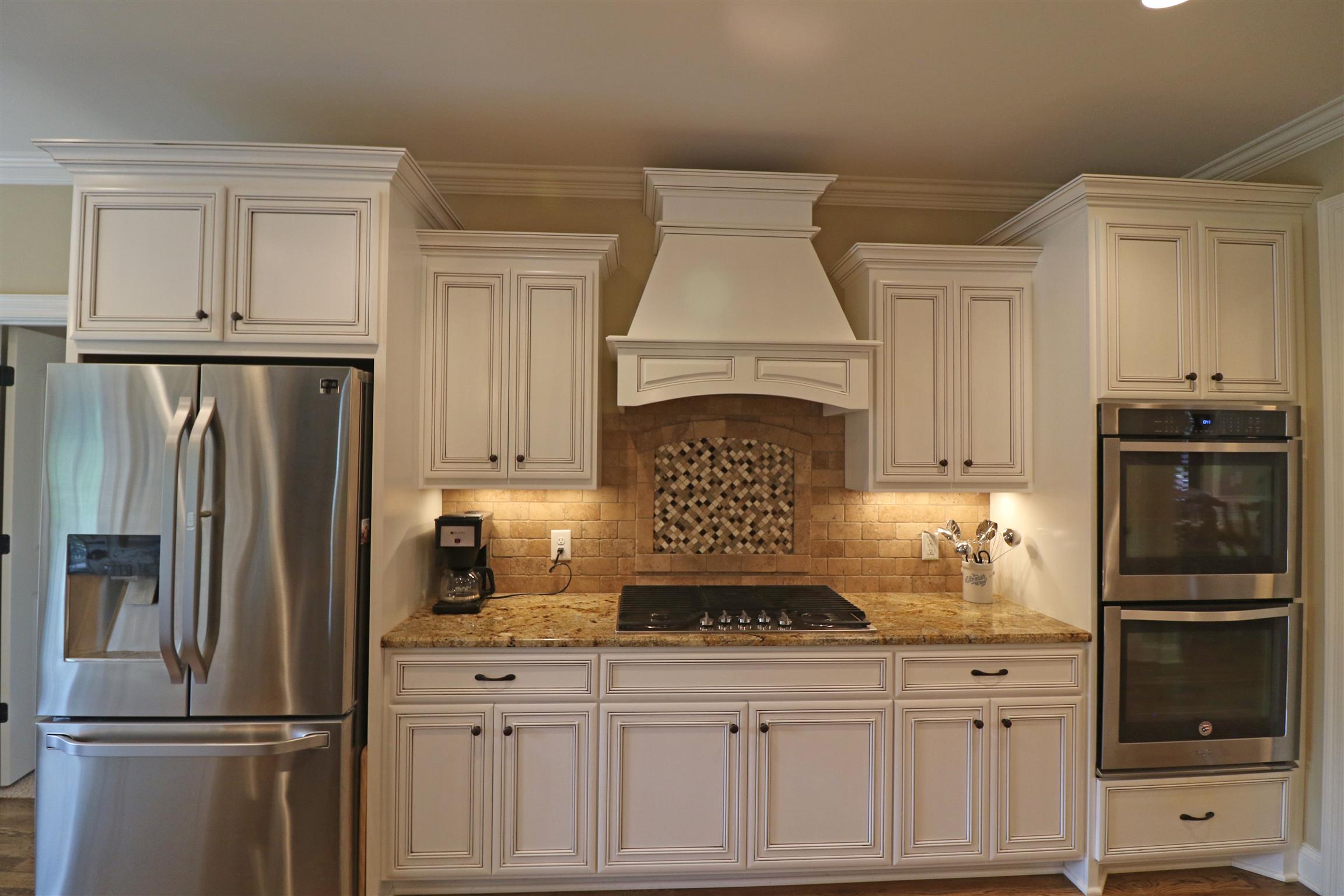 1235 Mires Road Mount Juliet, TN 37122 - Photo 10 of 30 Spacious 11x13 Kitchen design w/ upgraded custom cabinets, tile backsplash, under-cabinet lighting, raised breakfast bar with pendant lighting, crown molding, recessed lighting, gas cook-top, double ovens, microwave drawer, and hardwood flooring.