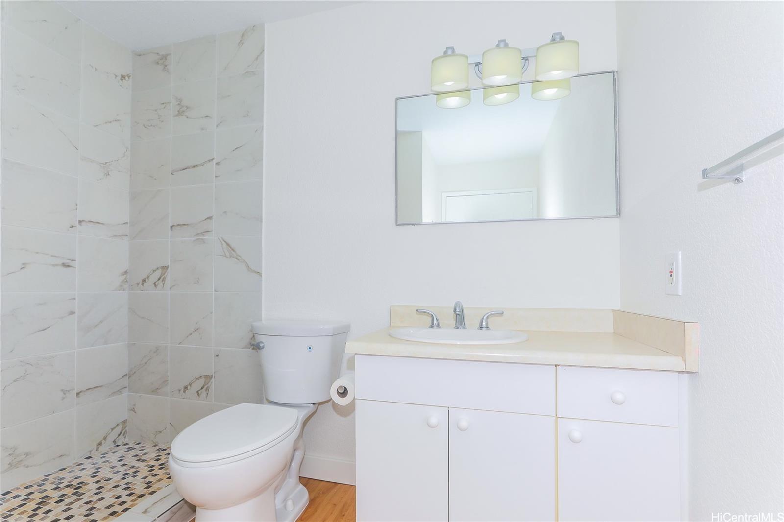 91-1101 Namahoe Street, Unit 3H Kapolei, HI 96707 - Photo 11 of 25 a bathroom with a sink toilet and a mirror