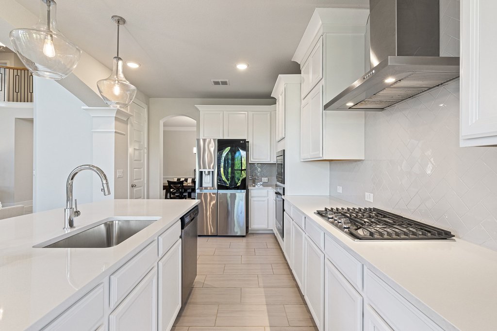 741 Rawson Bend Austin, TX 78738 - Photo 12 of 40 Featuring quartz surfaces, custom cabinetry, and built-in stainless appliances.
