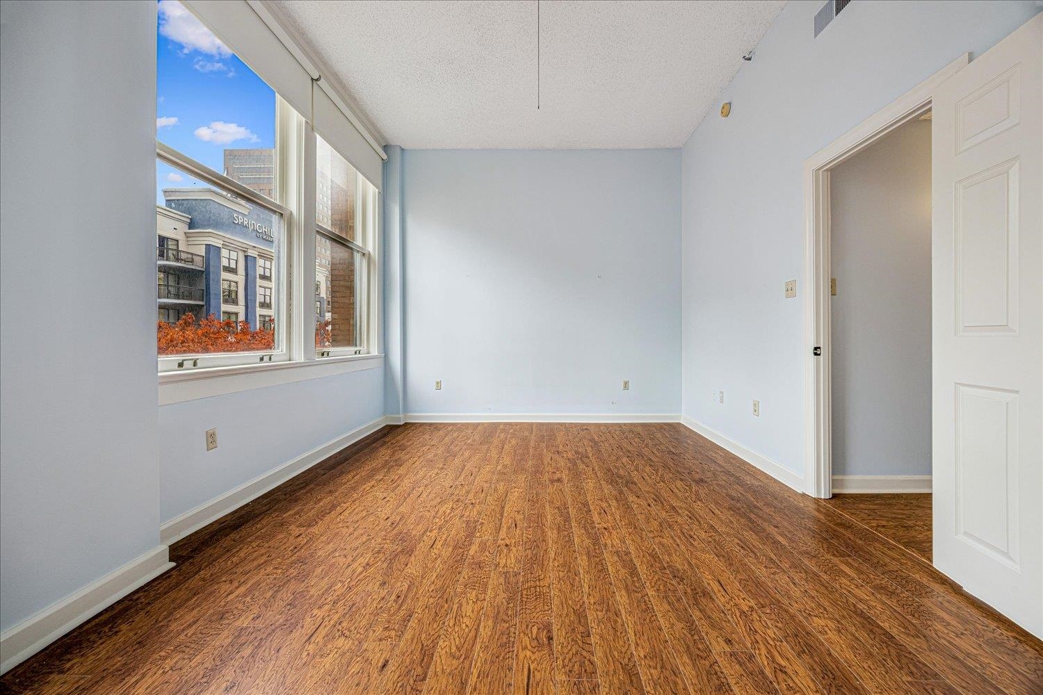 10 North Main Street, Unit 301 Memphis, TN 38103 - Photo 11 of 31 an empty room with wooden floor and windows