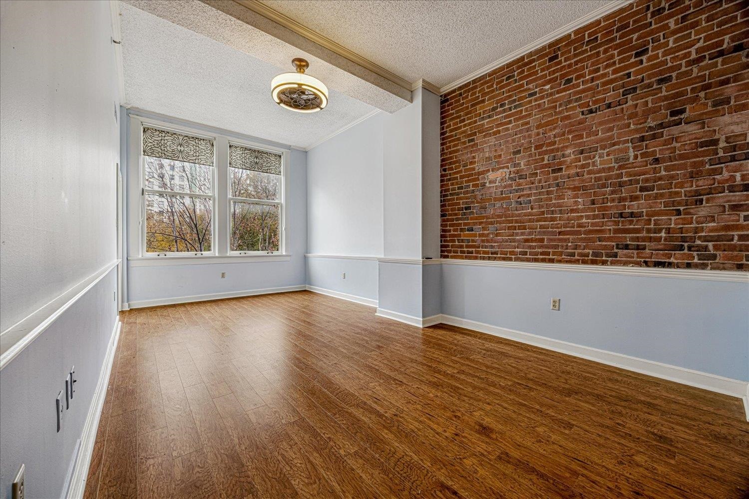 10 North Main Street, Unit 301 Memphis, TN 38103 - Photo 15 of 31 a view of an empty room with wooden floor and a window