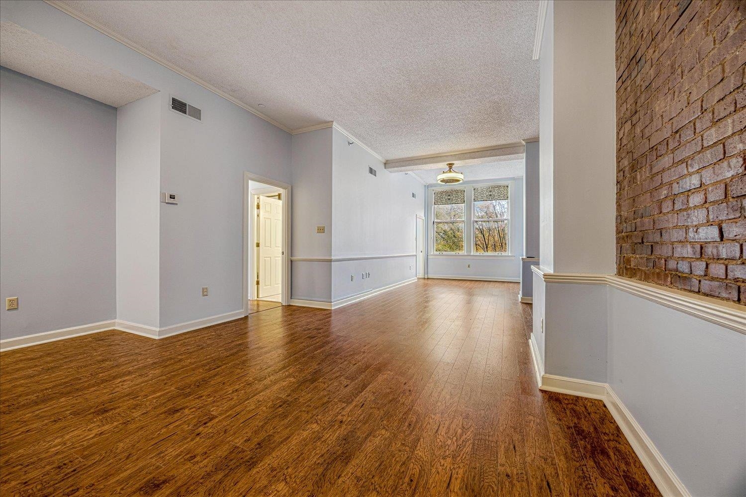 10 North Main Street, Unit 301 Memphis, TN 38103 - Photo 17 of 31 a view of an empty room with wooden floor and a window