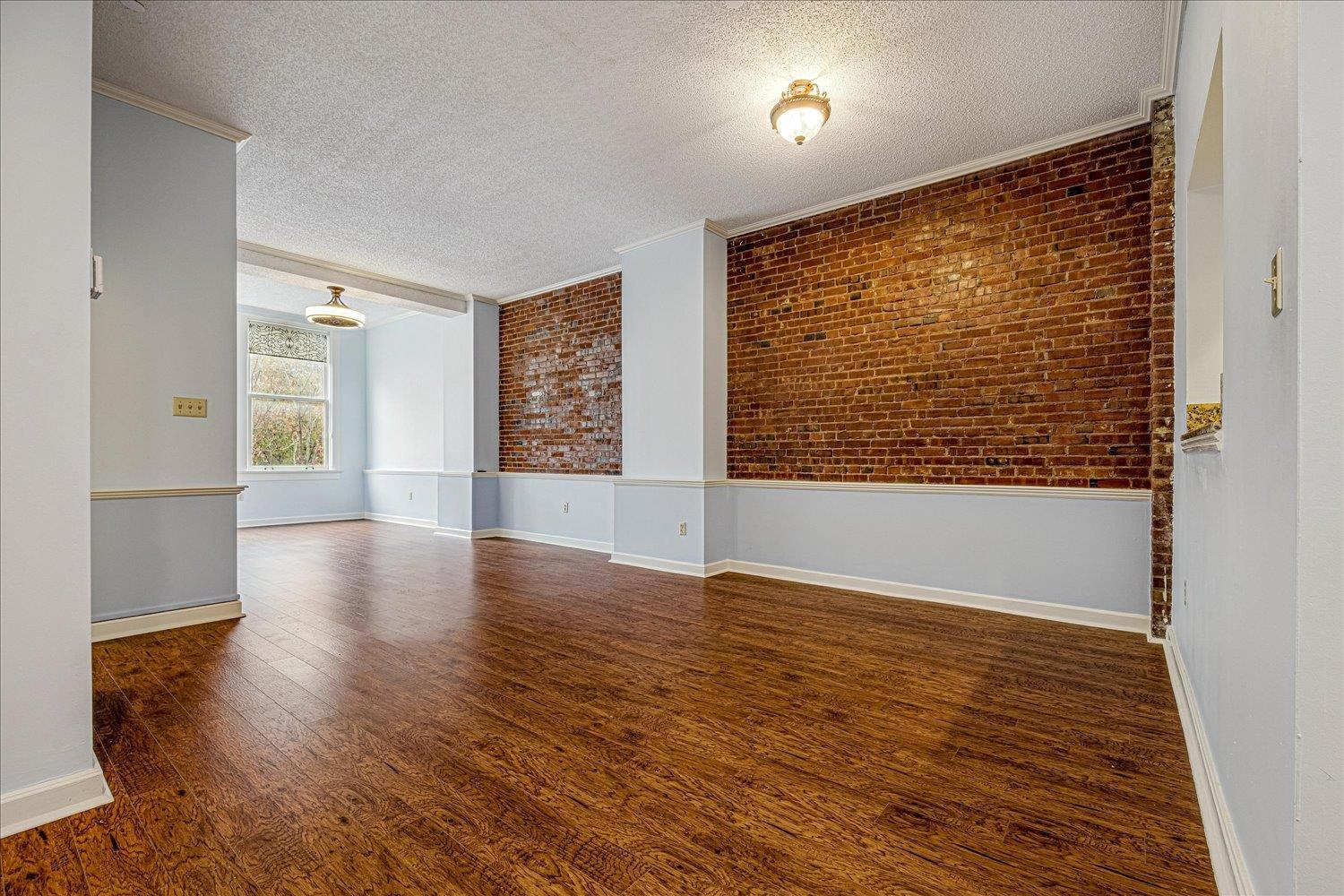 10 North Main Street, Unit 301 Memphis, TN 38103 - Photo 18 of 31 a view of an empty room with wooden floor and a window