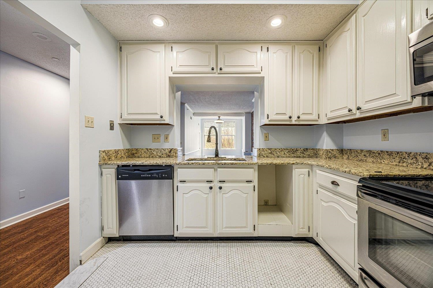 10 North Main Street, Unit 301 Memphis, TN 38103 - Photo 21 of 31 a kitchen with stainless steel appliances granite countertop a stove and white cabinets