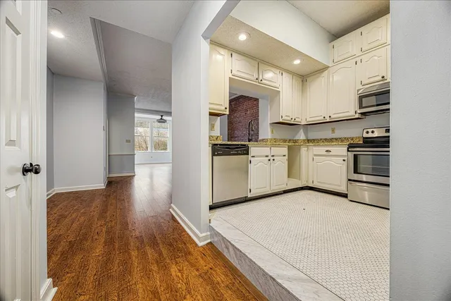 a kitchen with stainless steel appliances a stove top oven a sink and a refrigerator