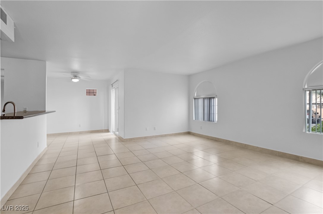 Unfurnished living room with plenty of natural light, light tile patterned floors, and ceiling fan