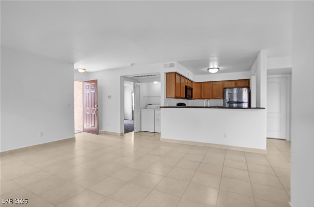 9325 West Desert Inn Road, Unit 177 Las Vegas, NV 89117 - Photo 3 of 13 Unfurnished living room with separate washer and dryer and baseboards
