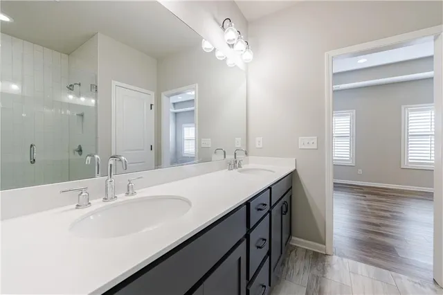 a bathroom with double vanity sinks a vanity lamp and a mirror
