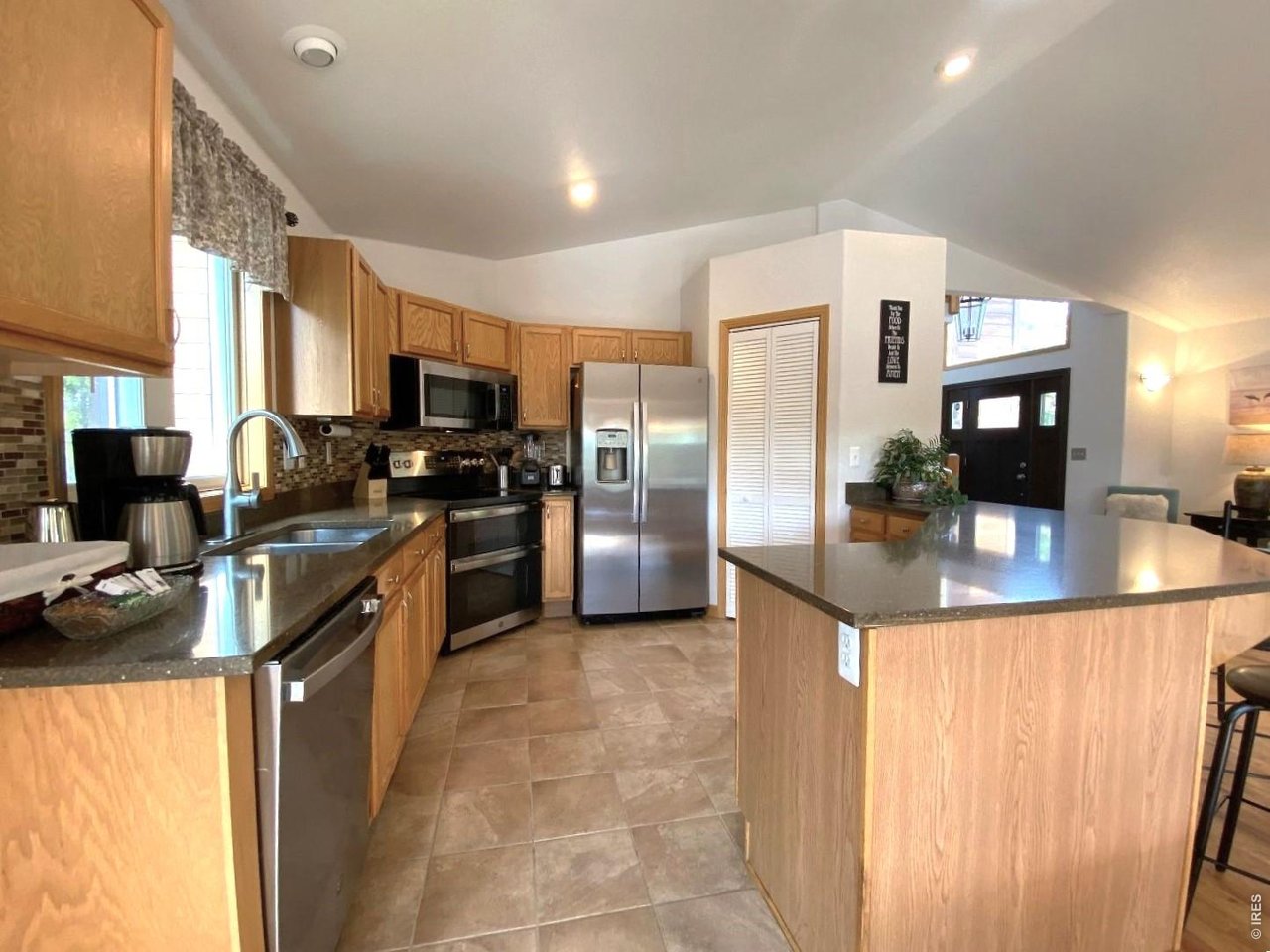 28 Valley View Lane Evergreen, CO 80439 - Photo 7 of 37 a kitchen with stainless steel appliances granite countertop a refrigerator a stove a sink a dining table and chairs with wooden floor