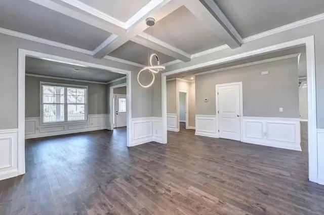 a view of a room with wooden floors and white walls