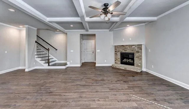 a kitchen with stainless steel appliances granite countertop a sink a stove a refrigerator and white cabinets with wooden floor