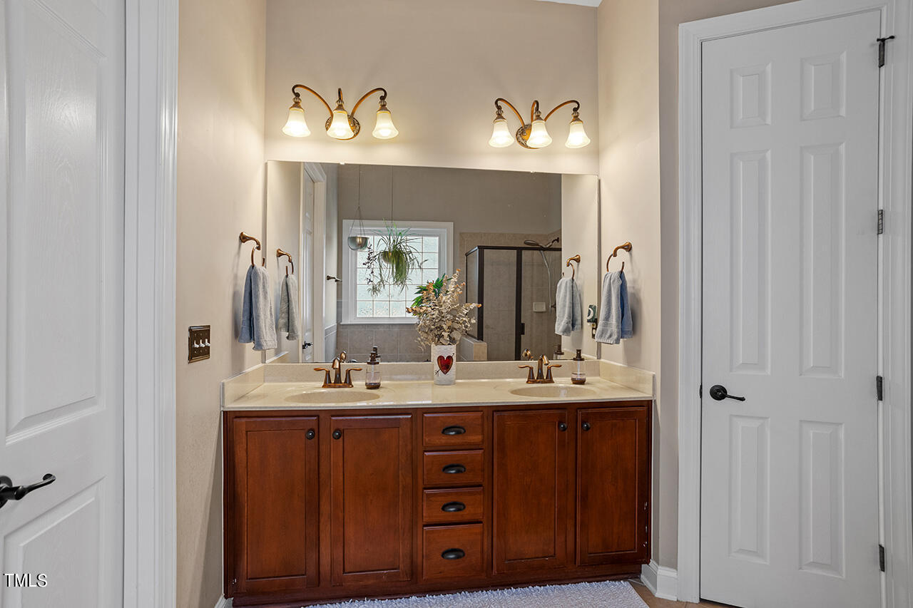 920 Chapanoke Road Raleigh, NC 27603 - Photo 19 of 47 a bathroom with a double vanity sink and a mirror