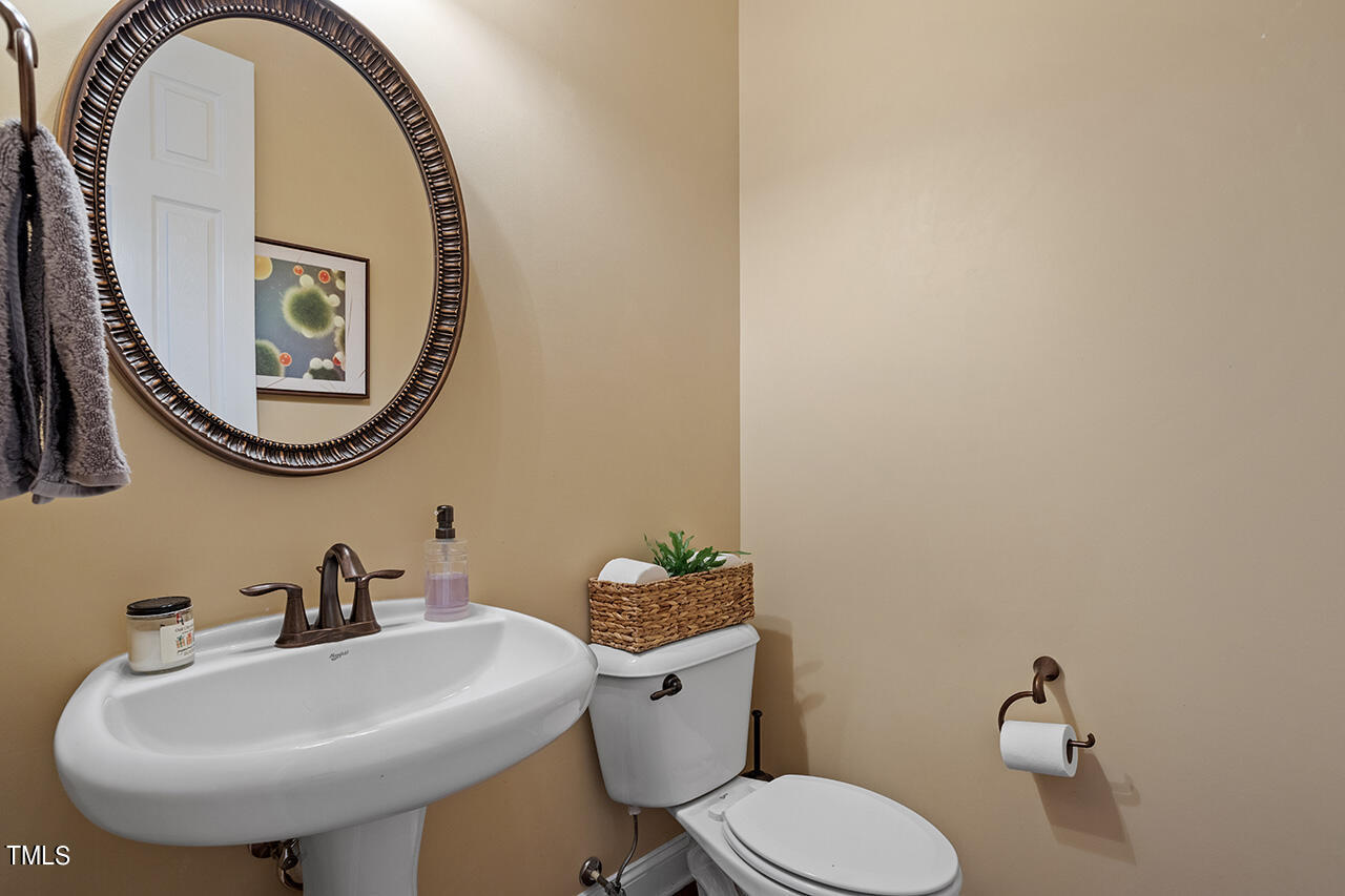 920 Chapanoke Road Raleigh, NC 27603 - Photo 31 of 47 a bathroom with a toilet a sink and a mirror