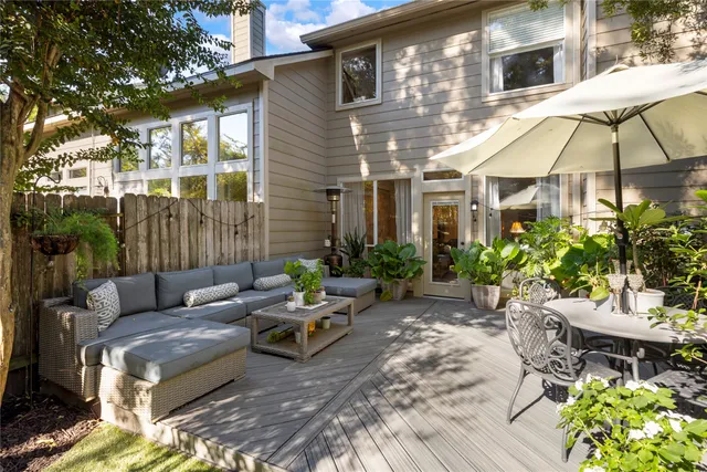 a backyard of a house with table and chairs under an umbrella