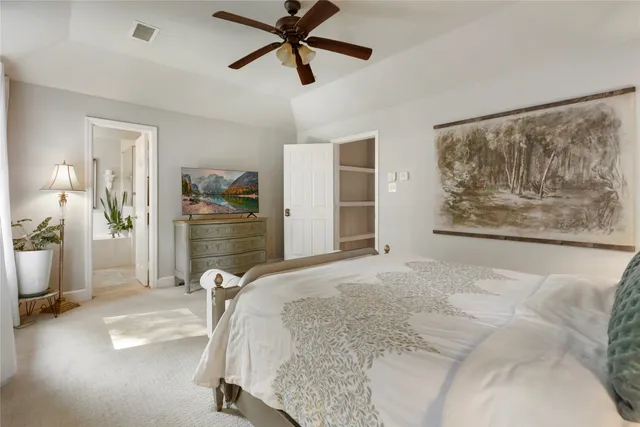 a spacious bedroom with a bed and ceiling fan